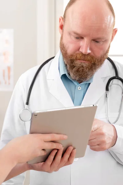 Læger diskuterer rapport om en patient på tablet computer på hospitalet - Stock-foto