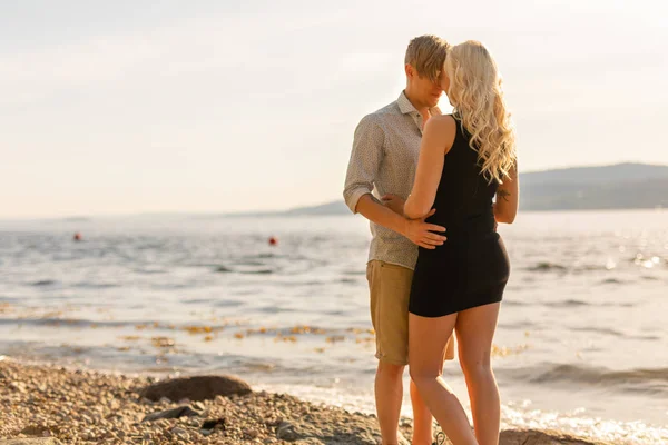 Beau jeune couple en étreinte romantique sur la plage en été — Photo