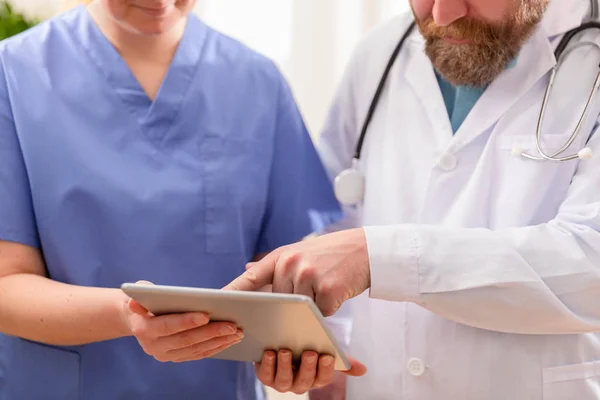 Læge og sygeplejerske diskuterer patienter test på tablet computer på hospitalet - Stock-foto