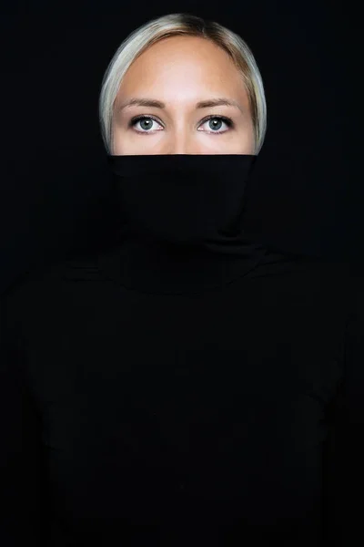 Студійний портрет красивої елегантної жінки, що ховається обличчям в чорному черепашці — стокове фото