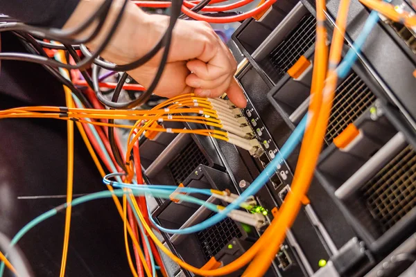 Ingegnere IT maschio Collegamento del cavo in fibra ad alta velocità nel commutatore di rete — Foto Stock