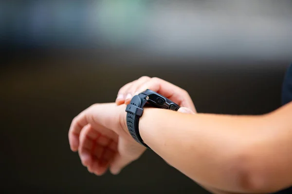 Female hands using fitness smart watch device after running