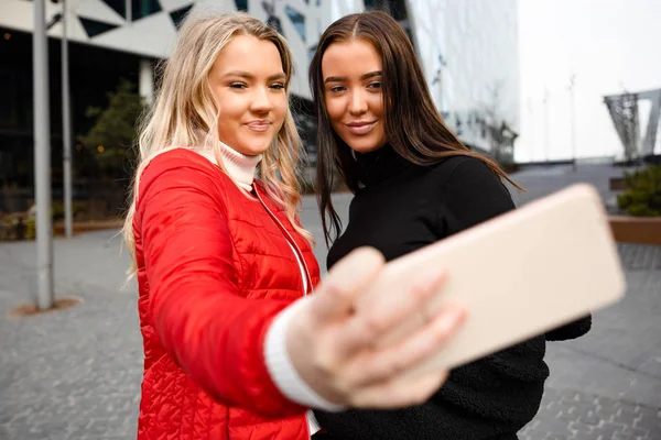 Şehir akıllı telefon aracılığıyla selfie alarak güzel arkadaşlar gülümseyen