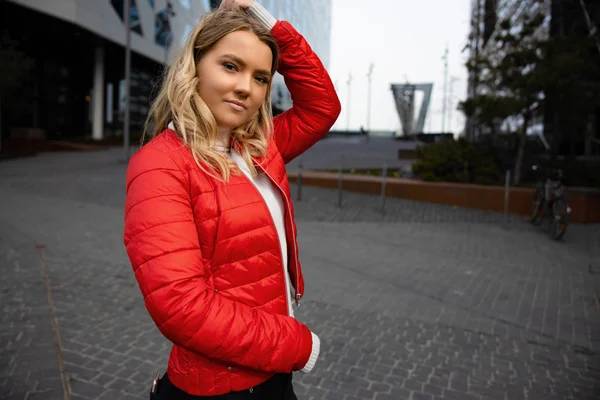 Ritratto di bella giovane donna bionda con la mano tra i capelli in città — Foto Stock