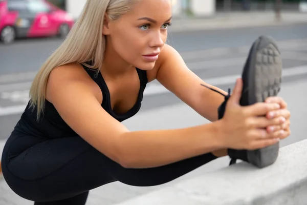 Focused Female Athlete Stretching Leg On Railing At Sidewalk — Stock Photo, Image