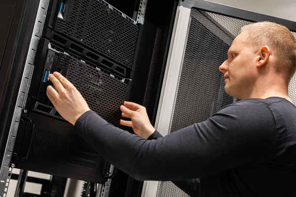 Técnico masculino enfocado que trabaja con servidores en el centro de datos — Foto de Stock