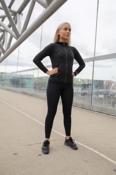 Szép nő, fekete edzés Wear állandó a modern Bridge in City — Stock Fotó