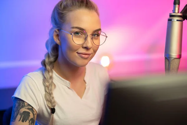 Porträt der blonden Spielerin mit Brille beim Online-Videospiel auf ihrem Computer — Stockfoto
