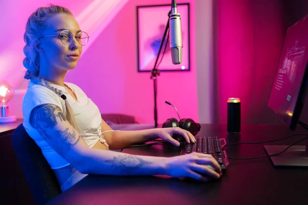 Šťastné krásné blondýny gamer dívka hrát online videohry na jejím osobním počítači. — Stock fotografie