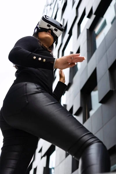 Focused Woman W okularach VR w futurystycznym i miejskim mieście — Zdjęcie stockowe
