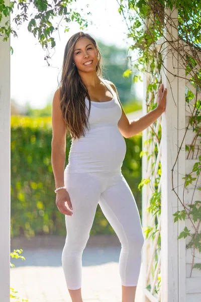 Heureuse femme enceinte debout en plein air dans le jardin — Photo