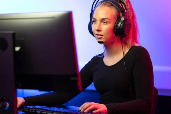 Profesional E-sport Gamer Chica con auriculares jugando videojuego en línea en PC —  Fotos de Stock
