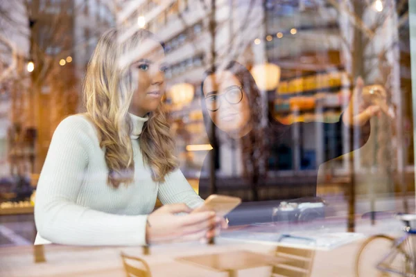 Mulheres conversando e olhando para fora janela no café na cidade — Fotografia de Stock
