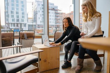 Şehirdeki kafede laptopta birlikte çalışan arkadaşlar.