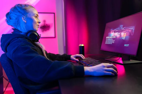 Chica gamer profesional con auriculares jugar videojuego multijugador en línea en PC — Foto de Stock