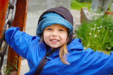 Mutlu kız mavi bir ceket bir salıncak üzerinde sürme