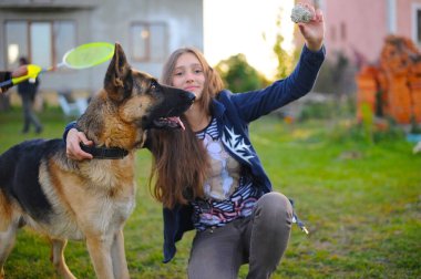 Kız, köpeğini yazın sokakta bir Alman çoban köpeği olarak eğitiyor. Köpeğe odaklan.