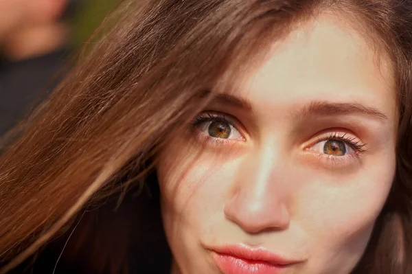 Gün batımında genç bir kızın portresi. Gülümsüyor ve dudaklarını merakla katlıyor.