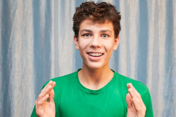 Joven Con Una Cara Graciosa Sonríe Con Una Camiseta Verde —  Fotos de Stock
