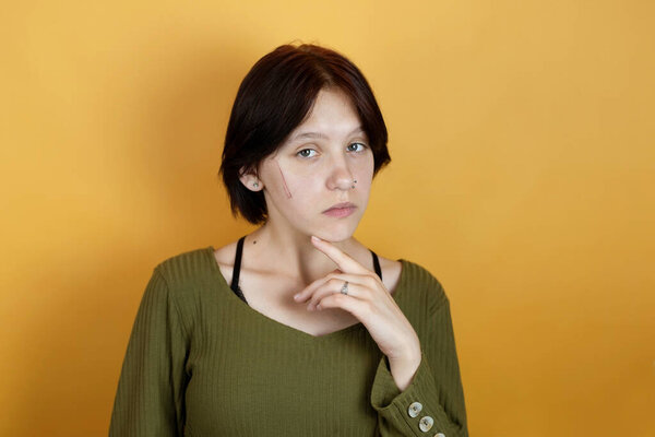 Молодая девушка-подросток с грустным лицом и эмоциями разочарования, она поцарапала лицо, девушка против насилия и унижения человеческой личности, скопировать пространство