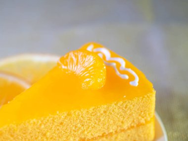 Beyaz çanak ve ahşap çatal turuncu kek masada.