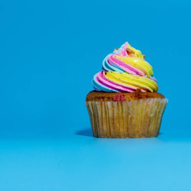Renkli ve mavi arka plan stüdyosu nda izole giren cupcake yakın çekim.
