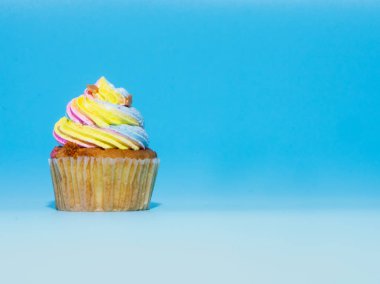 Renkli ve mavi arka plan stüdyosu nda izole giren cupcake yakın çekim.