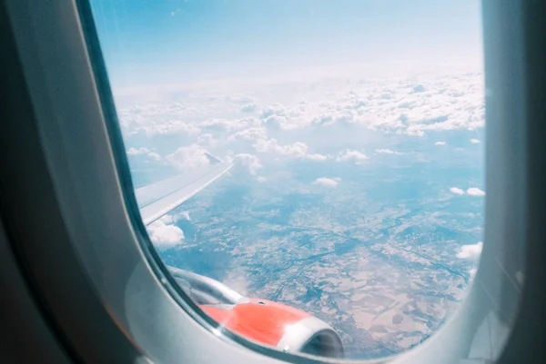 view of the cloudy sky, engine and wing of an airplane