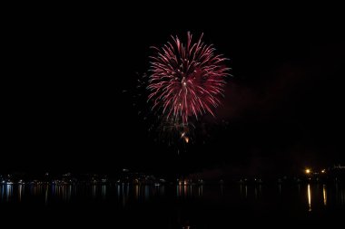 Bacoli, Napoli, 6 Ağustos 2019. Havai fişekler gökyüzünü çeşitli renklerde boyayın ve Miseno gölüne yansıyarak nefes kesici bir panorama oluşturur..