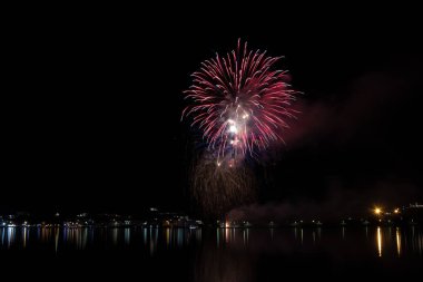 Bacoli, Napoli, 6 Ağustos 2019. Havai fişekler gökyüzünü çeşitli renklerde boyayın ve Miseno gölüne yansıyarak nefes kesici bir panorama oluşturur..