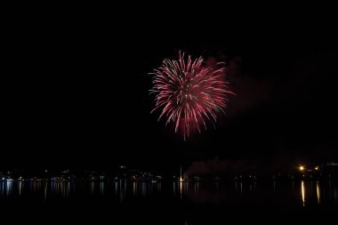 Bacoli, Napoli, 6 Ağustos 2019. Havai fişekler gökyüzünü çeşitli renklerde boyayın ve Miseno gölüne yansıyarak nefes kesici bir panorama oluşturur..
