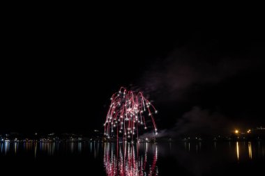 Bacoli, Napoli, 6 Ağustos 2019. Havai fişekler gökyüzünü çeşitli renklerde boyayın ve Miseno gölüne yansıyarak nefes kesici bir panorama oluşturur..