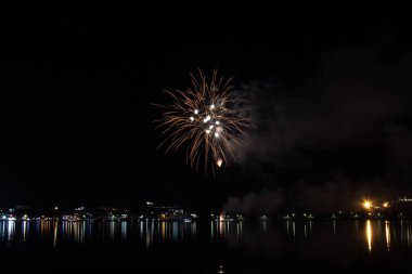 Bacoli, Napoli, 6 Ağustos 2019. Havai fişekler gökyüzünü çeşitli renklerde boyayın ve Miseno gölüne yansıyarak nefes kesici bir panorama oluşturur..