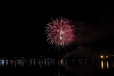 Bacoli, Napoli, 6 Ağustos 2019. Havai fişekler gökyüzünü çeşitli renklerde boyayın ve Miseno gölüne yansıyarak nefes kesici bir panorama oluşturur..