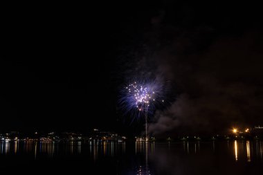 Bacoli, Napoli, 6 Ağustos 2019. Havai fişekler gökyüzünü çeşitli renklerde boyayın ve Miseno gölüne yansıyarak nefes kesici bir panorama oluşturur..