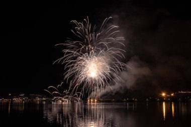 Bacoli, Napoli, 6 Ağustos 2019. Havai fişekler gökyüzünü çeşitli renklerde boyayın ve Miseno gölüne yansıyarak nefes kesici bir panorama oluşturur..