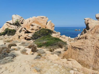 Kuzey Sardunya 'nın engebeli kıyı şeridi boyunca uzanan Cala Sarraina, kızıl uçurumları, turkuaz suları ve bozulmamış manzaralarıyla büyülenir.