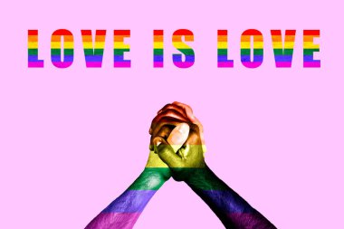 Eşcinsel gururunun gökkuşağı renkleriyle birleşmiş çok kültürlü bir çiftin elleri. LGBT hakları hareketi ve cinsiyet eşitliği kavramı