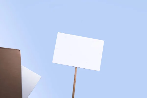 Holding a blank sign at a demonstration. Poster for the copy space with blue background.