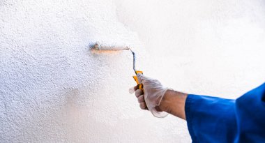 İsimsiz biri duvarları teker teker boyuyor. Evi boyama ve ıslah etme kavramı.