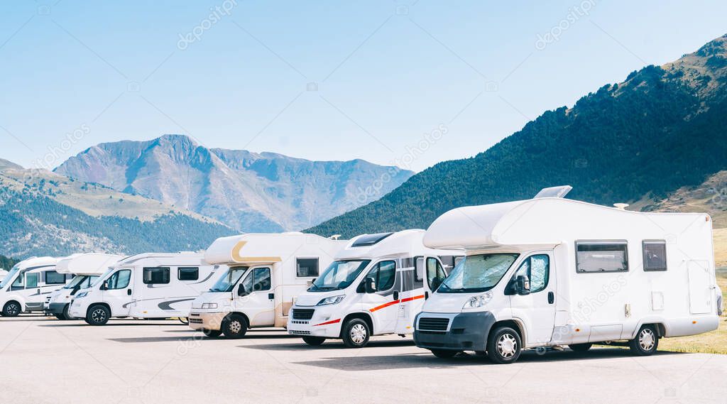 RV parking in the mountain at vacations. Caravans parked in a camper parking area. Concept of summer tourism with recreational vehicle.