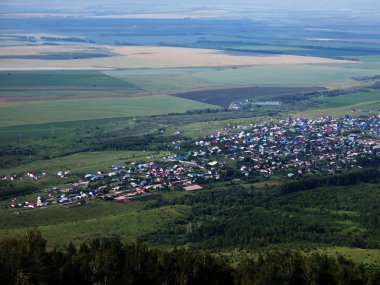 Köy, yukarıdan küçük bir kasaba manzarası. Tepeler arasında yazlık evler,