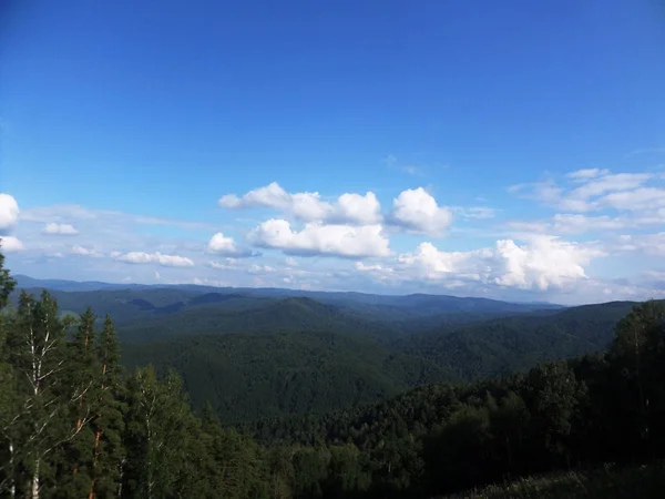 Paysage d'été vue de dessus. Collines, forêt de conifères et ciel bleu — Photo