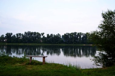 Nehrin yanında bir bank. Yaz akşamı.