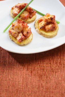 Ahtapot ile patates başlayanlar, kutlama için catering sunumu. Renkli masa örtüsü üzerinde servis edilir.