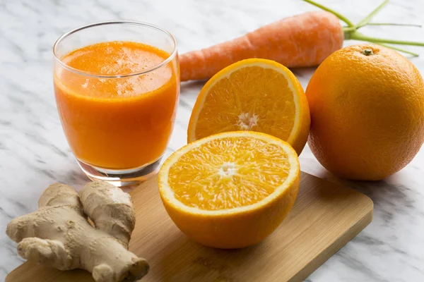 健康的なオレンジ、ニンジン、生姜ジュース。上から見た白い大理石の背景の構図. — ストック写真