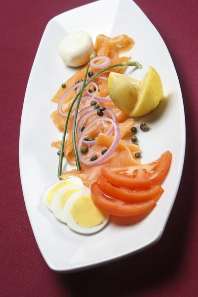 Salát z lososa podávaný na bílém talíři, výhled shora. — Stock fotografie