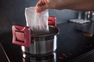 Yemek için porsiyon torbalarda karabuğday. Buğday lapası pişirme, bir kadın bir pot pişirme için bir çanta koyar