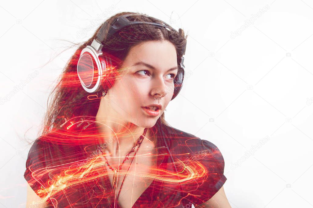 Girl fan sings and dances listening to music. Young brunette woman in big headphones enjoys music