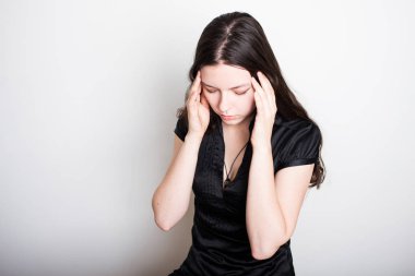 Genç bayan baş ağrısından muzdarip. Kafasını tutan bir kızın portresi. Migren ve kan basıncı sorunları